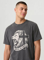 A man wearing a dark gray graphic t-shirt featuring a white illustration of a lion and cross with the text 'MAN OF FAITH' on a light gray background.