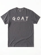 A dark gray short-sleeve t-shirt with 'G.O.A.T GOD OVER ALL THINGS' print across the chest.