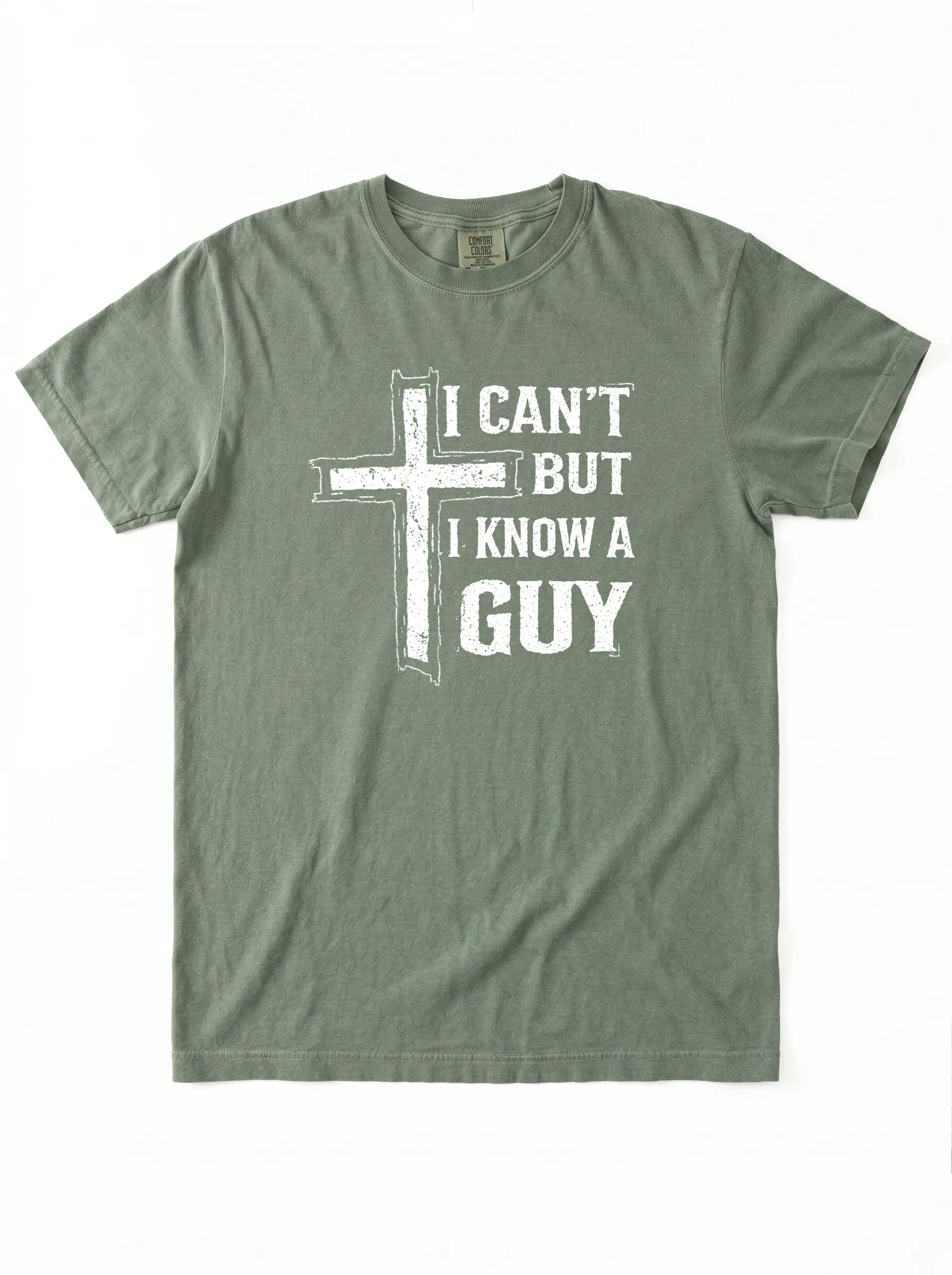 An olive green short-sleeve t-shirt with a white graphic print on the front featuring a distressed cross and the text 'I CAN'T BUT I KNOW A GUY'.