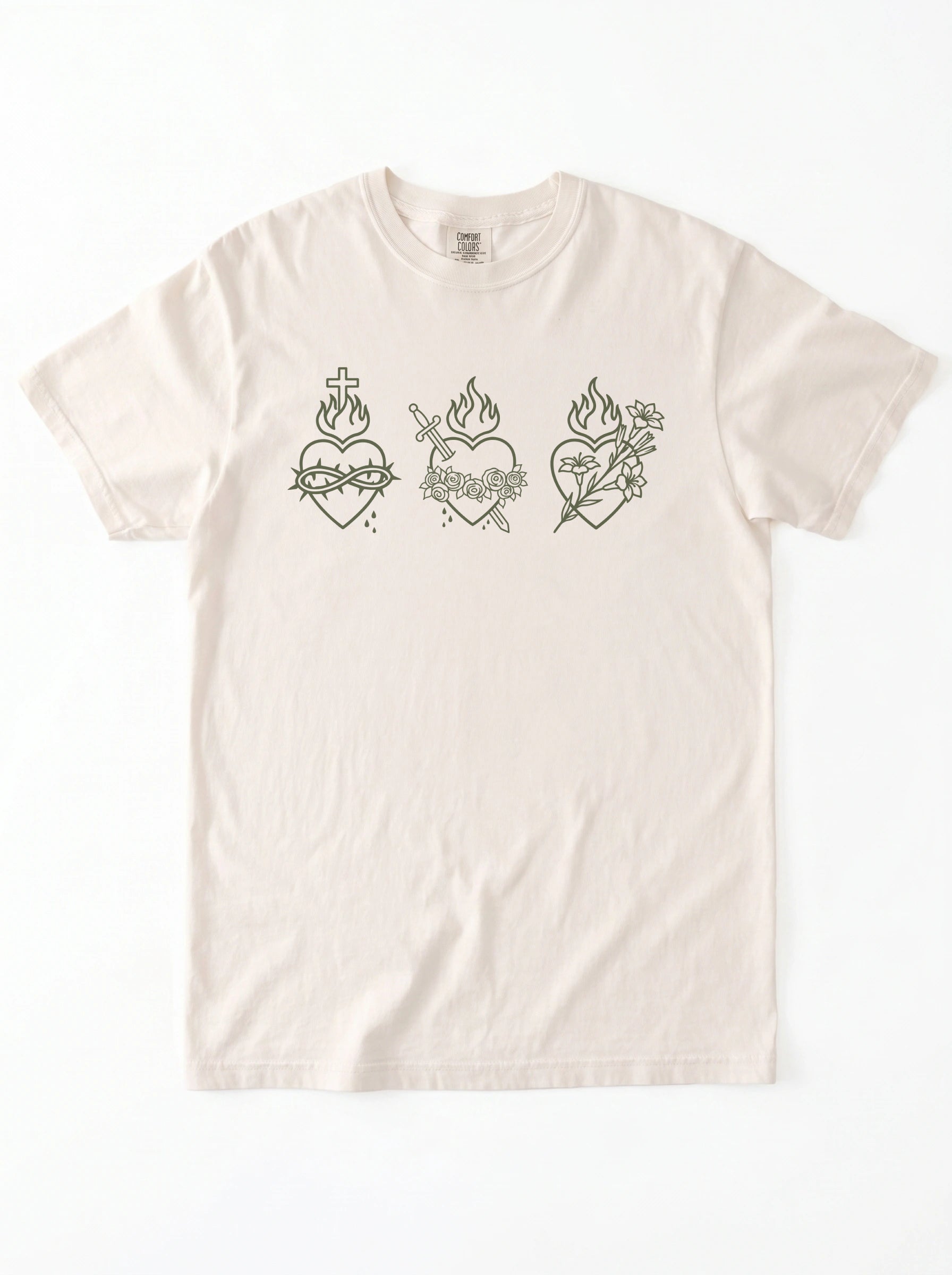An off-white short-sleeve t-shirt with three dark green Sacred Heart line-art graphics across the chest, displayed flat against a white background.