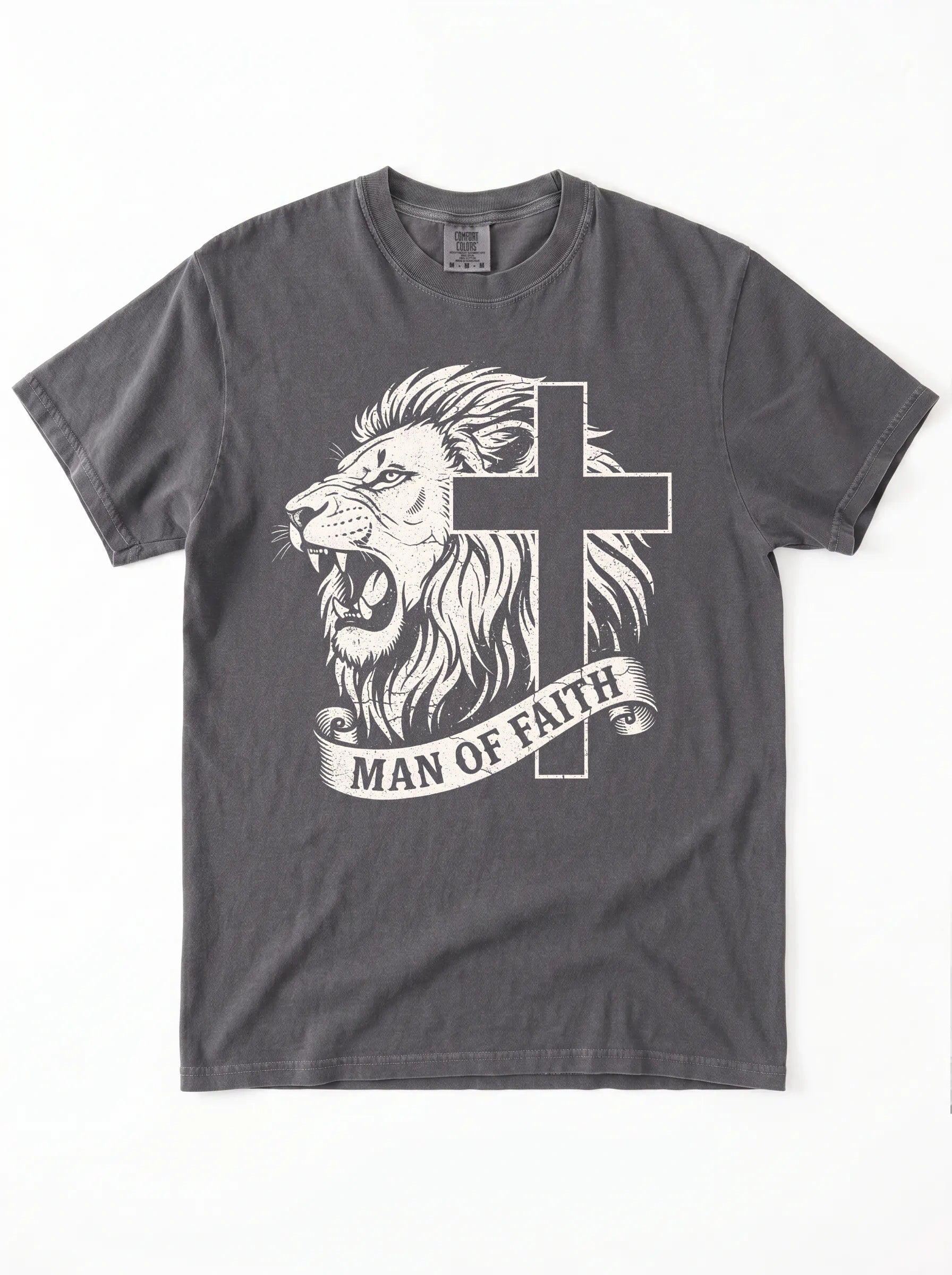 A dark gray crewneck t-shirt featuring a graphic print of a roaring lion and a cross, with a banner below reading 'MAN OF FAITH' in white text, shown flat against a white background.
