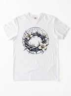 A white short-sleeve crewneck t-shirt featuring a graphic print of a crown of thorns and white lilies, featuring Greek text.