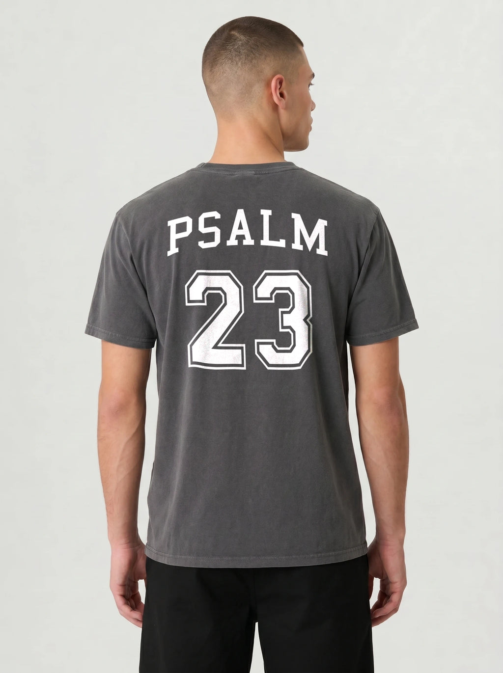 Man wearing pepper gray Comfort Colors t-shirt with Psalm 23 varsity print on the back