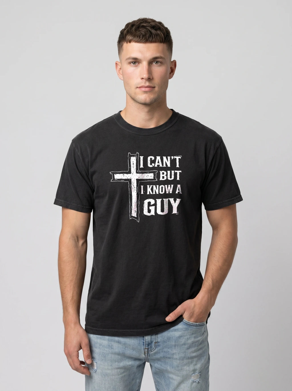 A man wearing a black crewneck t-shirt with a white distressed graphic of a cross and the text 'I CAN'T BUT I KNOW A GUY'.