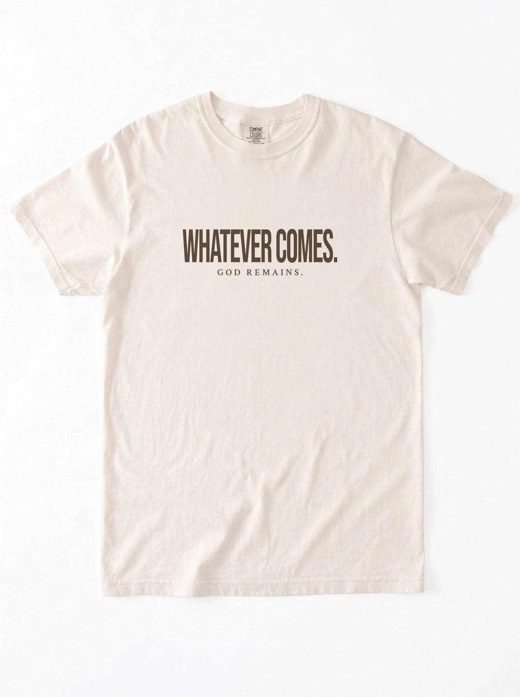 A light beige crewneck t-shirt with the text 'WHATEVER COMES. GOD REMAINS.