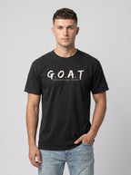 A man wearing a black short-sleeve t-shirt with 'G.O.A.T GOD OVER ALL THINGS' print across the chest.