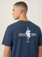 A man shown from the back wearing a navy blue t-shirt with a white graphic print on the back featuring a gladiator helmet and the text 'HELMET OF SALVATION' and 'SWORD OF THE SPIRIT'.