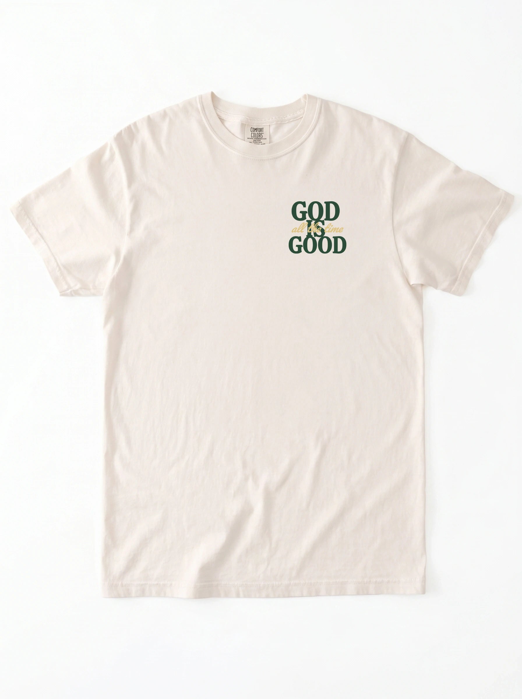 An off-white short-sleeve t-shirt with a graphic on the left chest that reads 'GOD IS GOOD' in dark green and yellow.