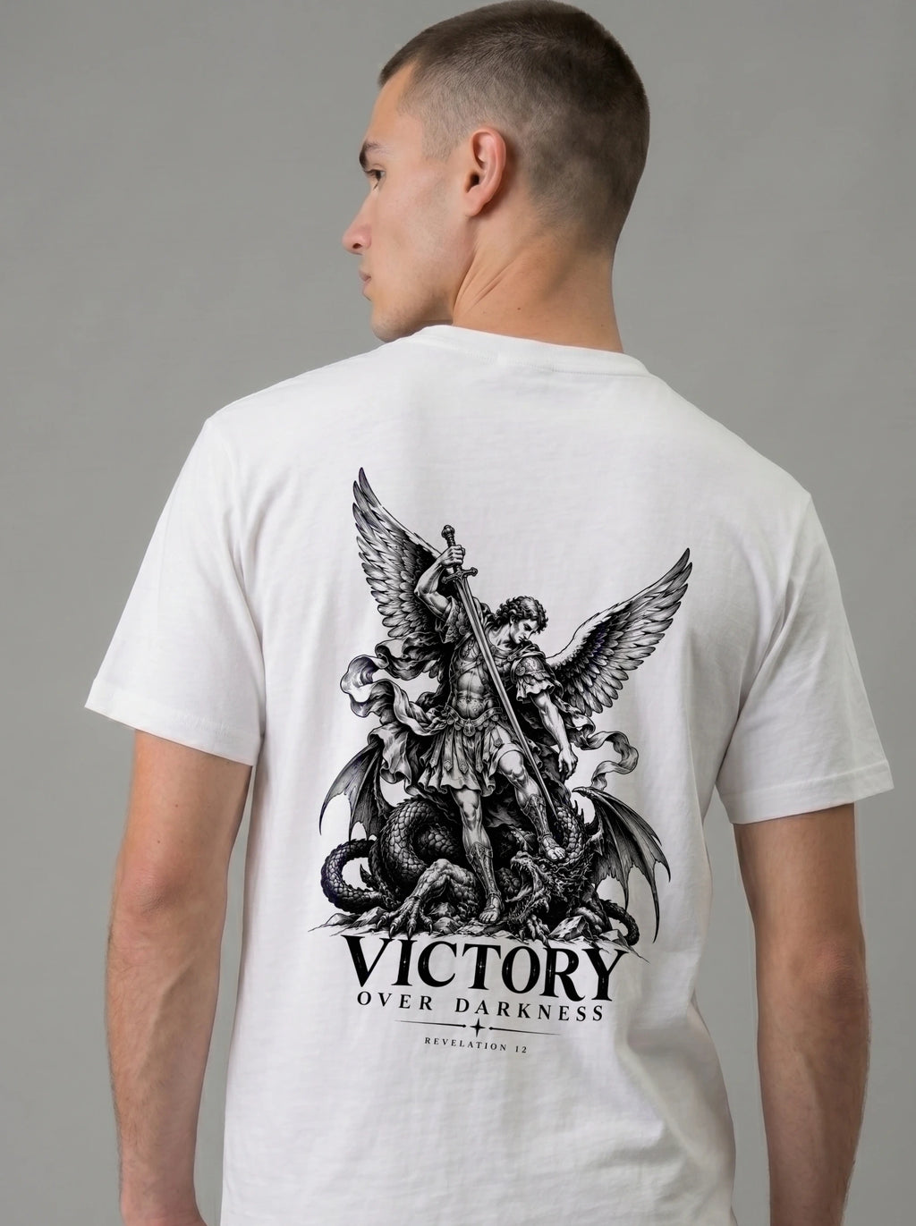 White T-shirt with a winged warrior defeating a dragon and the text “VICTORY OVER DARKNESS” and “REVELATION 12.”