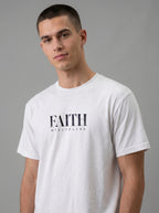 Person wearing a white T-shirt with distressed black text reading “FAITH” and “DISCIPLINE.”