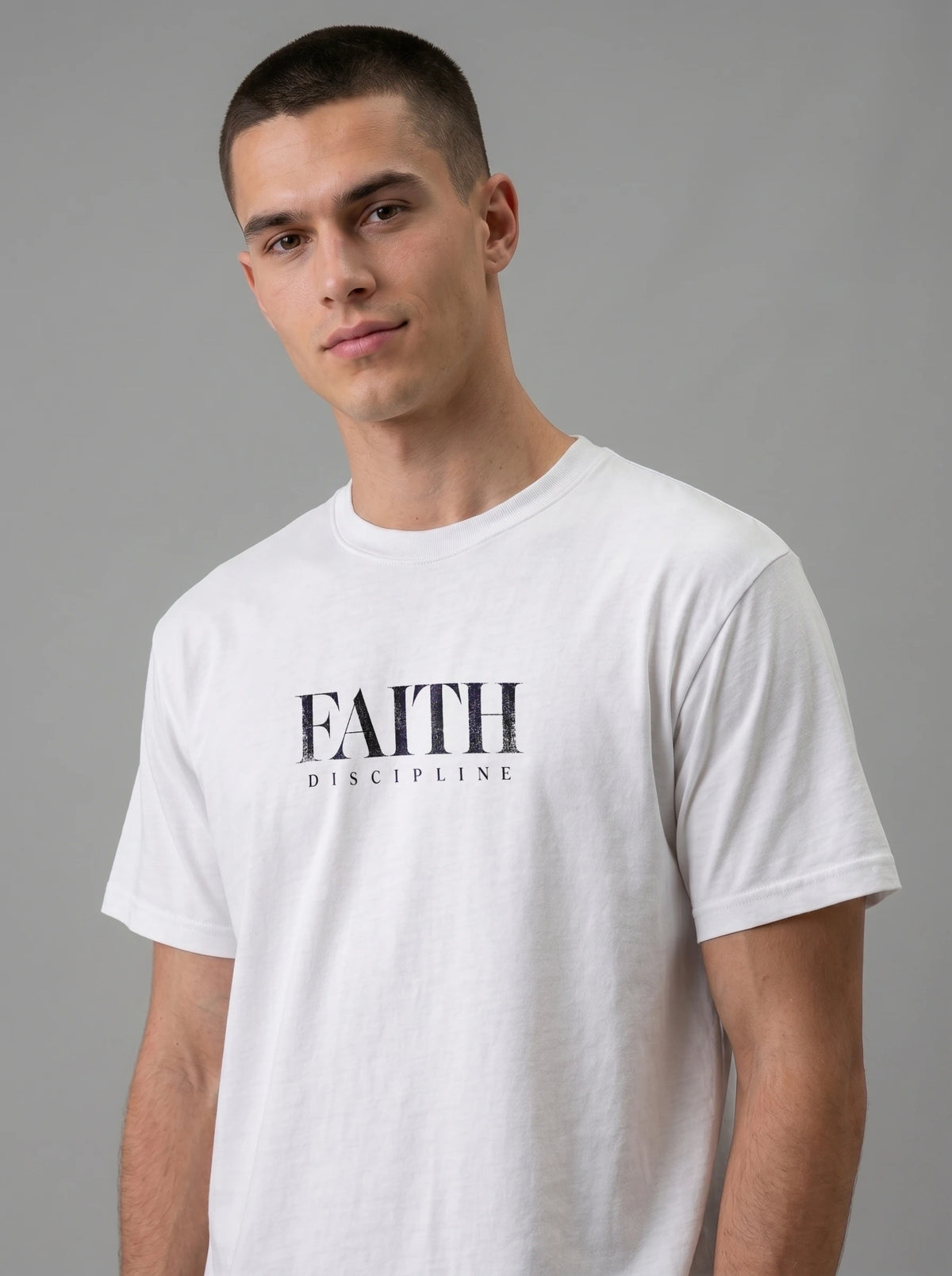 Person wearing a white T-shirt with distressed black text reading “FAITH” and “DISCIPLINE.”