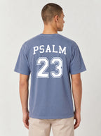 Man wearing blue jean Comfort Colors t-shirt with Psalm 23 varsity print on the back
