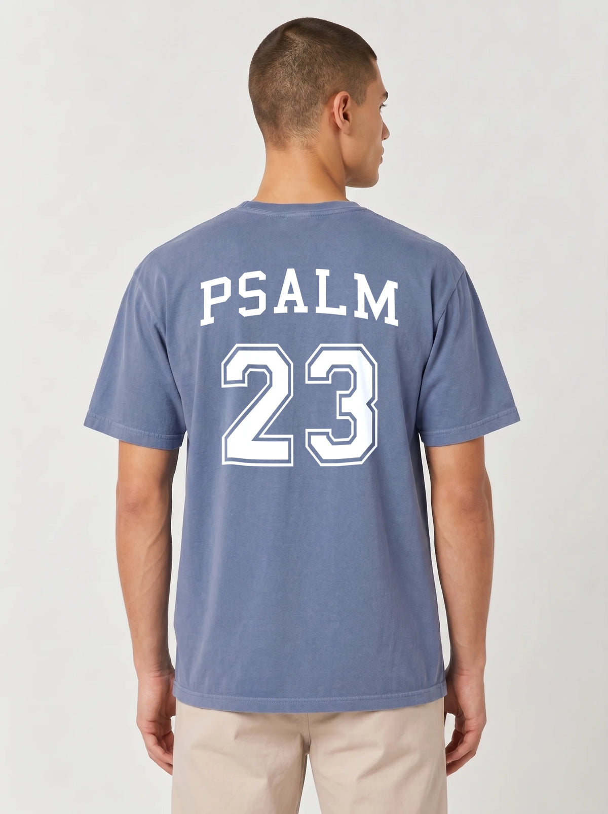 Man wearing blue jean Comfort Colors t-shirt with Psalm 23 varsity print on the back
