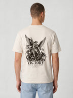 Cream T-shirt with a winged warrior defeating a dragon and the text “VICTORY OVER DARKNESS” and “REVELATION 12.”