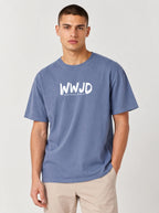 A man wearing a heathered blue crewneck t-shirt with a white 'WWJD' graphic on the chest, paired with beige pants, photographed against a light gray studio background.