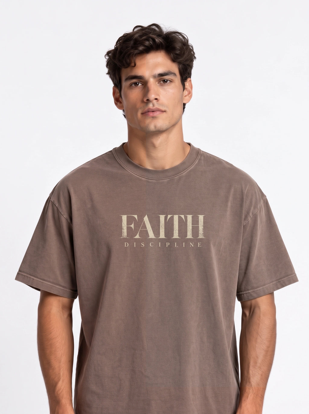 Person wearing a faded brown T-shirt with distressed beige text reading “FAITH” and “DISCIPLINE.”