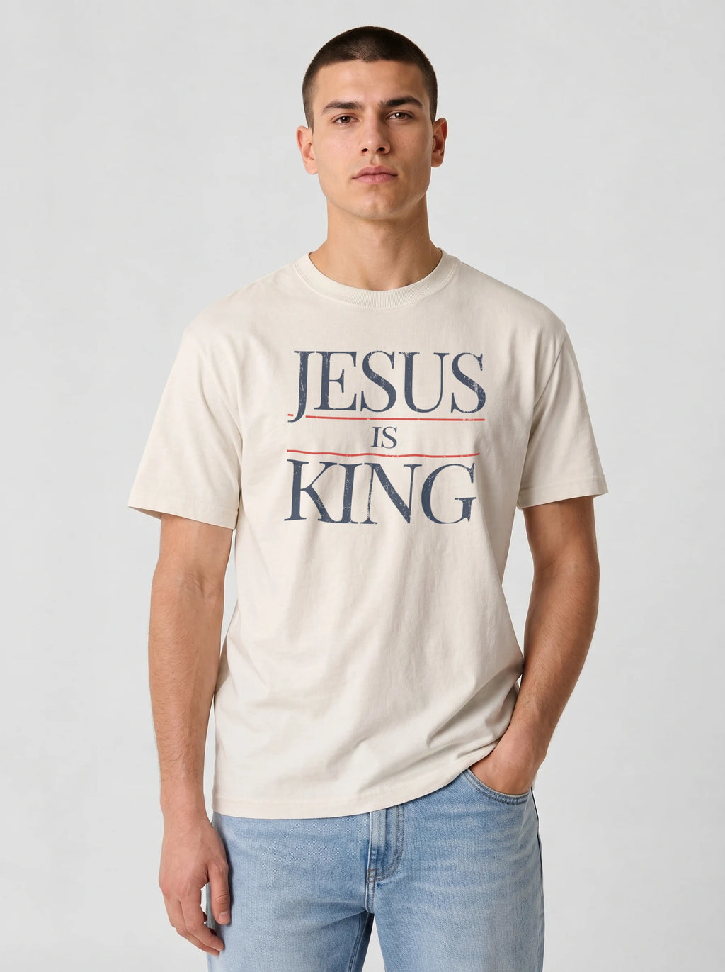 Man wearing cream Comfort Colors Jesus Is King graphic t-shirt, front view