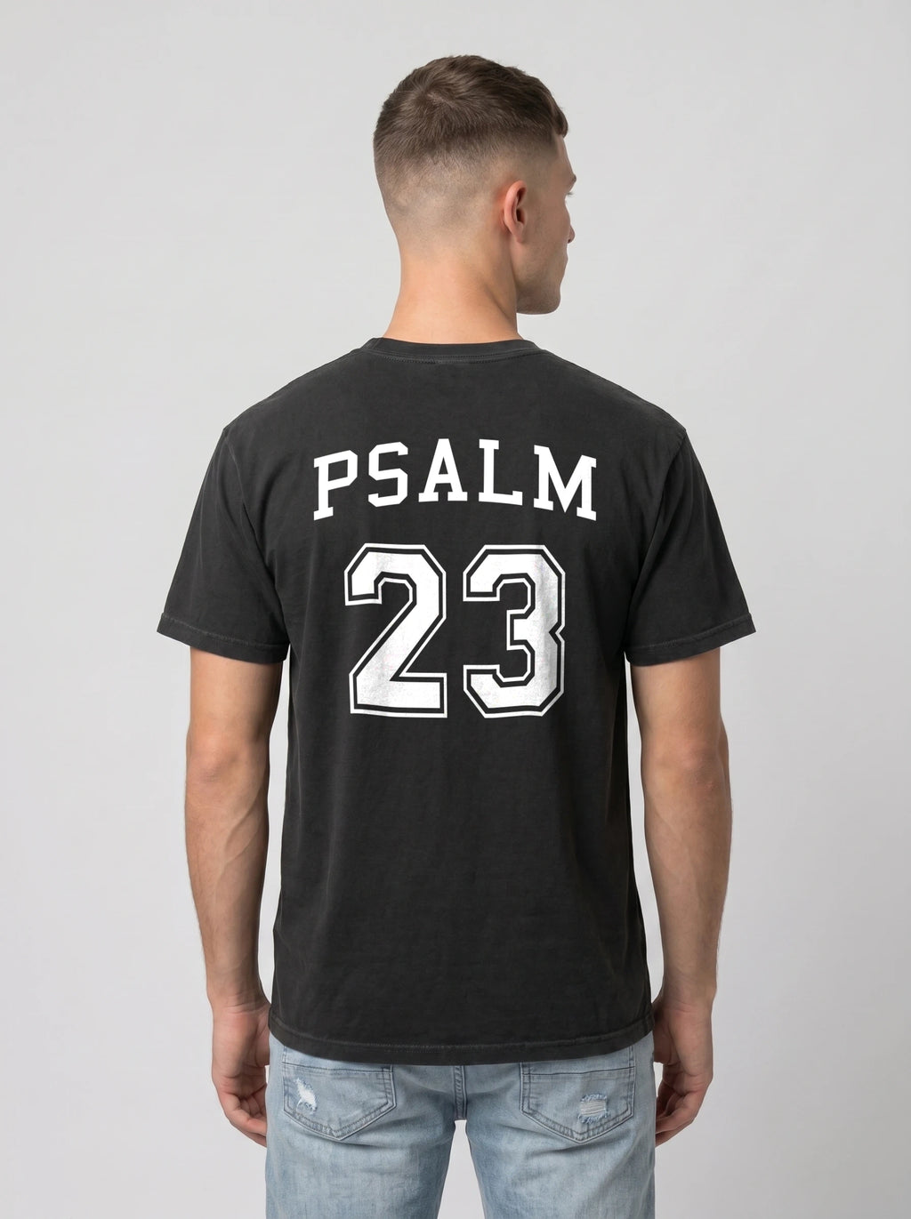 Man wearing black Comfort Colors t-shirt with Psalm 23 varsity print on the back, faith-based graphic tee
