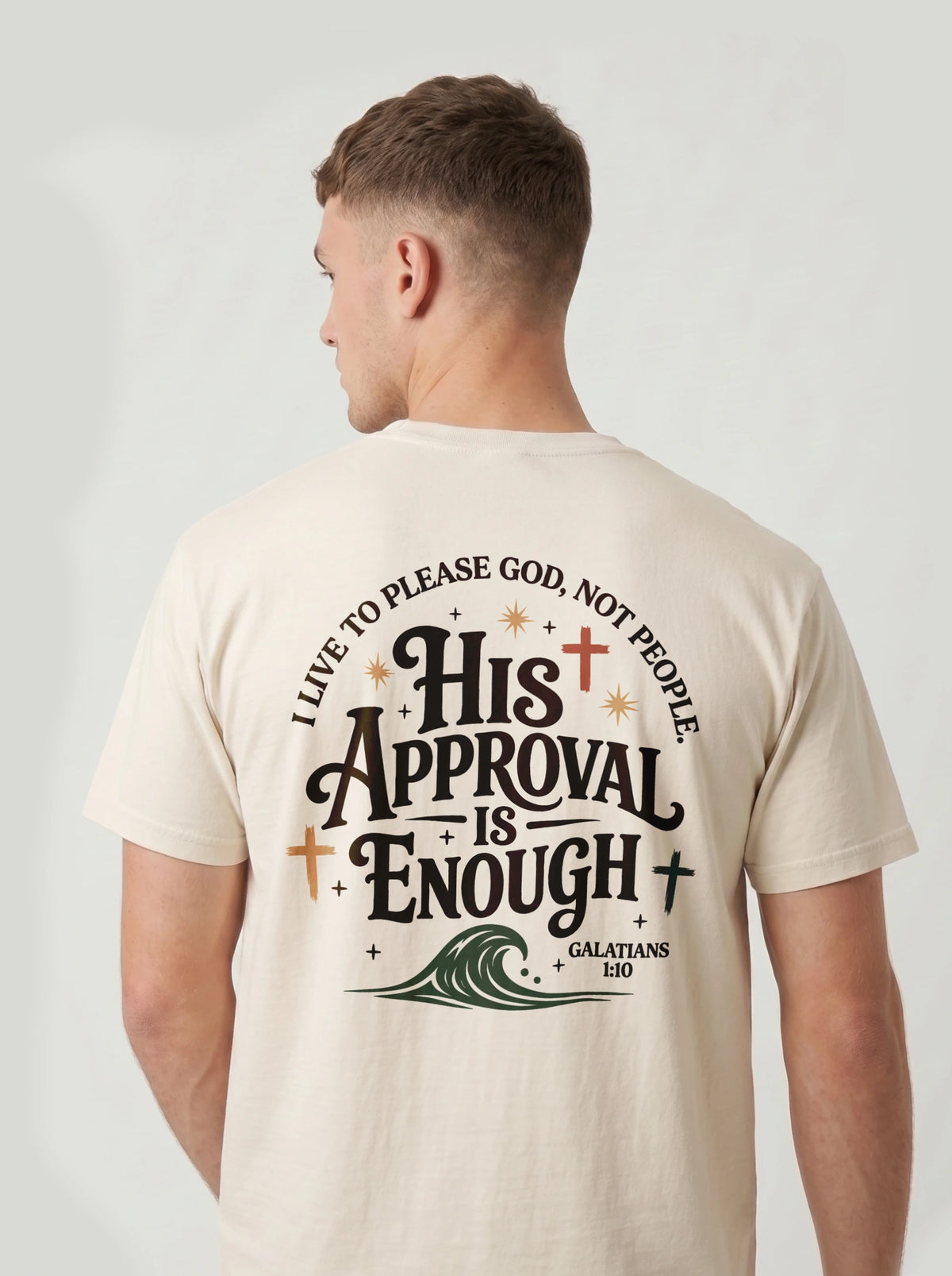 Man wearing cream Comfort Colors t-shirt with 'His Approval Is Enough' faith-based graphic design on the back, Galatians 1:10