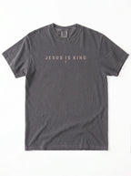 Faded charcoal T-shirt laid flat with “Jesus Is King” and a small cross printed across the chest.
