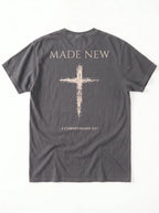 Flat lay back view of dark gray Comfort Colors tee with Made New cross design and 2 Corinthians 5:17 verse