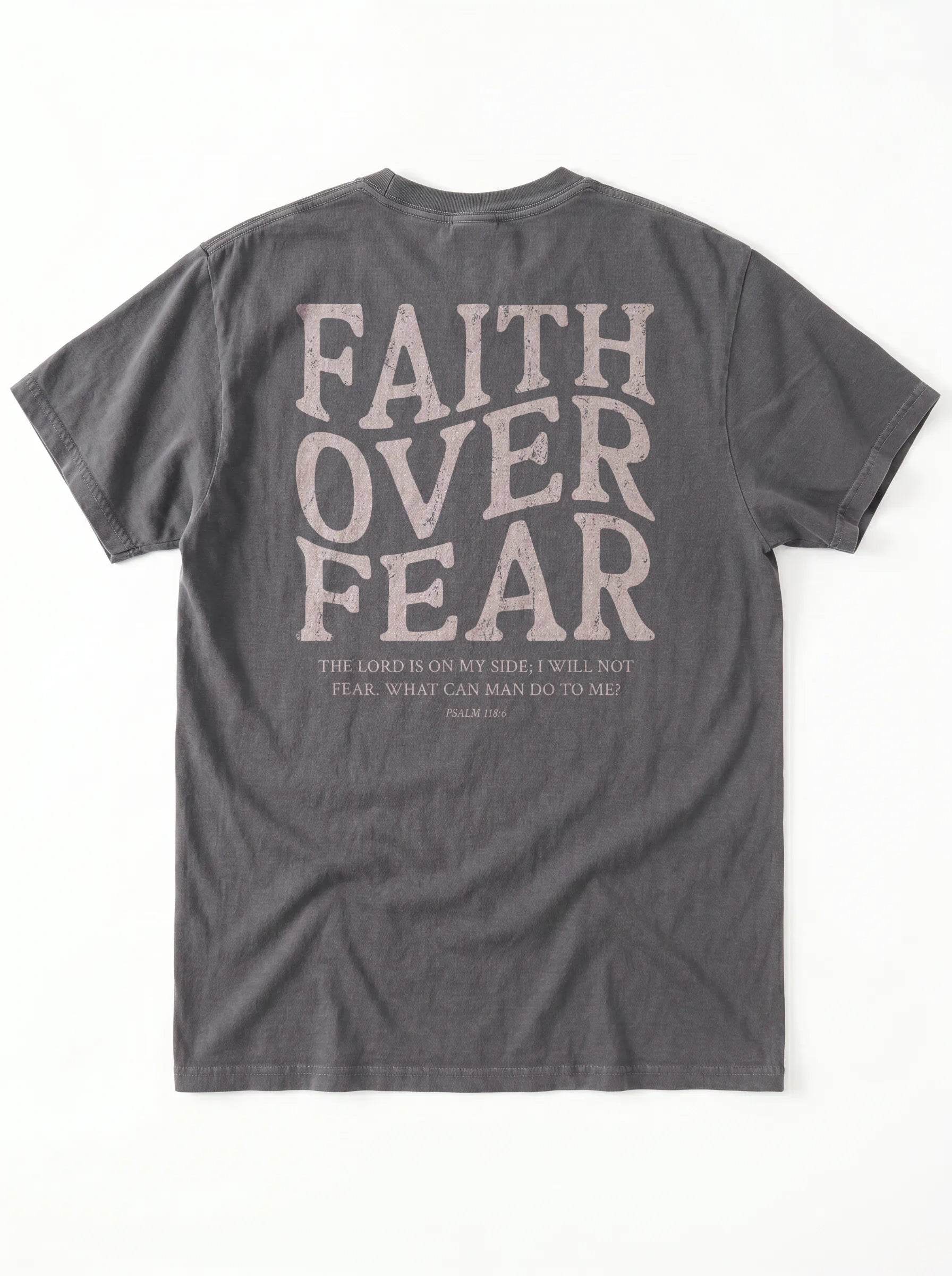 A dark gray crewneck t-shirt shown from the back, featuring a large distressed light beige graphic that reads 'FAITH OVER FEAR' with a bible verse printed underneath.