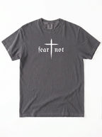 A dark gray crewneck t-shirt featuring a white graphic on the chest with a cross and the gothic text 'fear not'.