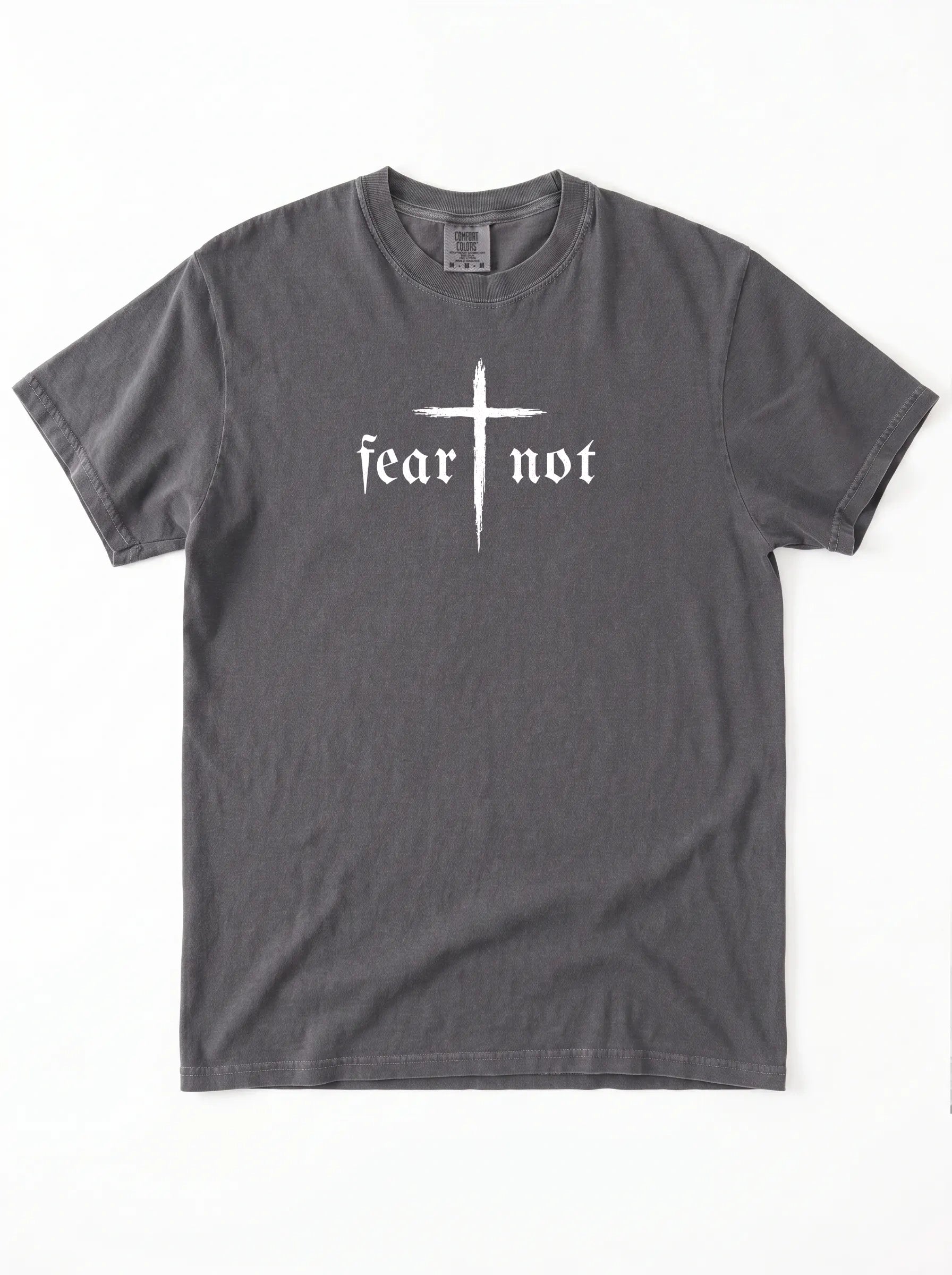 A dark gray crewneck t-shirt featuring a white graphic on the chest with a cross and the gothic text 'fear not'.