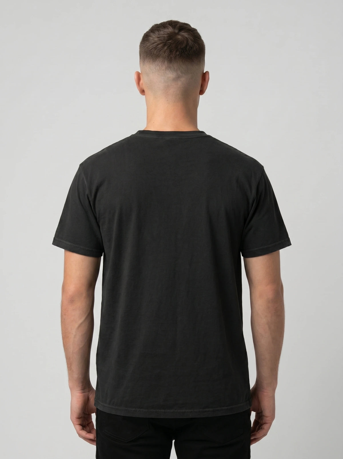 Back view of a person wearing a plain black T-shirt.
