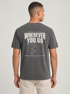 A man viewed from the back wearing a dark gray mineral-washed t-shirt with a large white graphic print on the back that reads 'WHEREVER YOU GO' and 'FOR THE LORD YOUR GOD IS WITH YOU'.