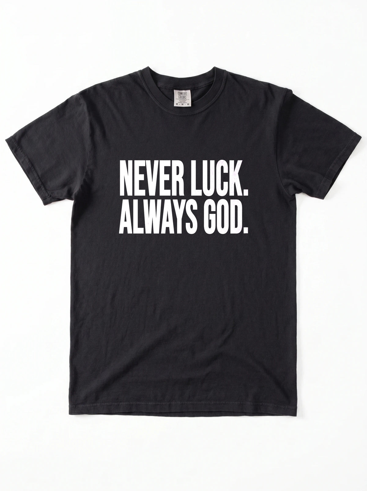 Black T-shirt laid flat with white text reading “Never luck. Always God.”