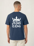 A man viewed from the back wearing a navy blue t-shirt with a white graphic print of a crown and the text 'JESUS IS KING'.