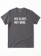 Flat lay of charcoal gray Comfort Colors 1717 garment-dyed t-shirt with 'His Glory. Not Mine.' print