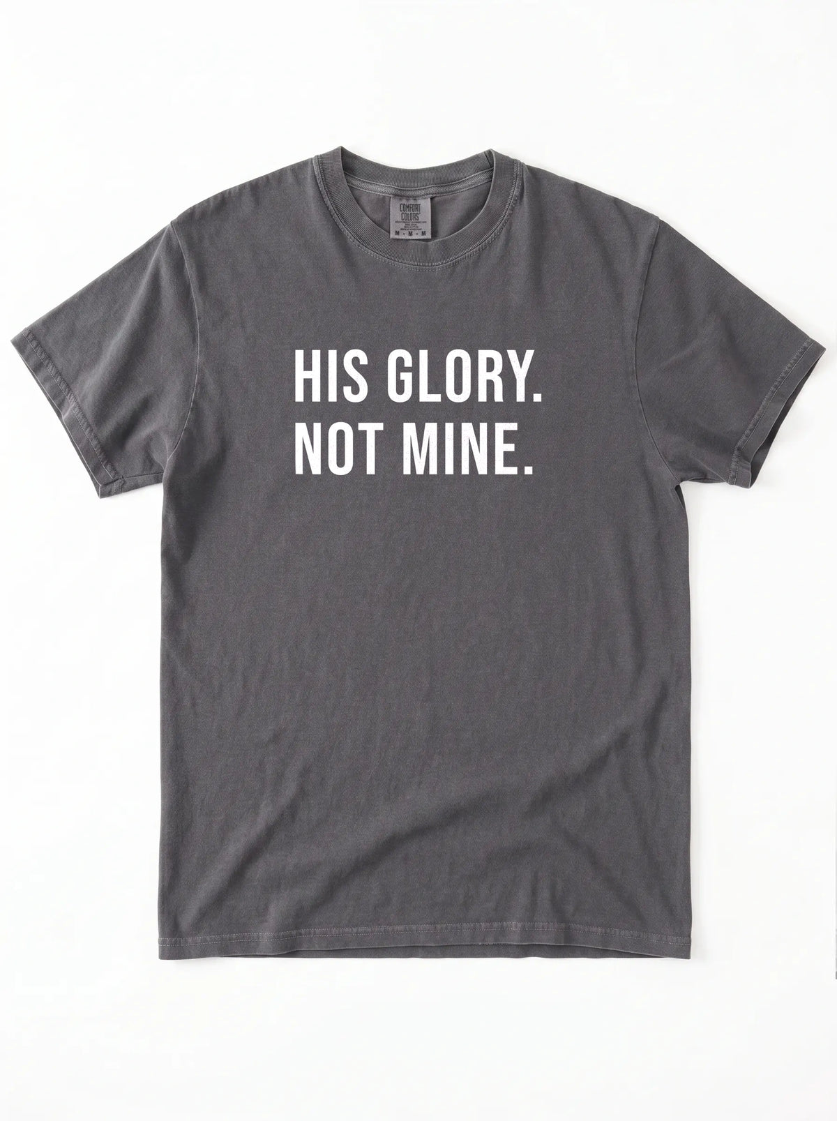 Flat lay of charcoal gray Comfort Colors 1717 garment-dyed t-shirt with 'His Glory. Not Mine.' print