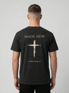 Man wearing black Comfort Colors t-shirt with Made New cross graphic and 2 Corinthians 5:17 verse on back