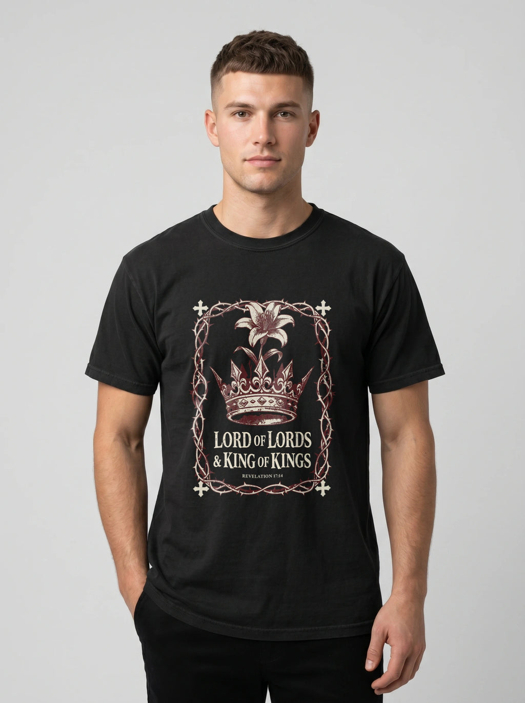 A man wearing a black crewneck t-shirt with a graphic print of a crown and the text 'LORD of LORDS & KING of KINGS' on the front, set against a plain light gray background.