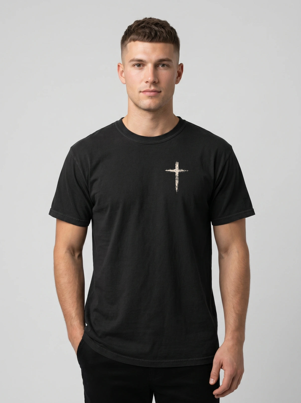 Man wearing black Comfort Colors t-shirt with small cross graphic on left chest