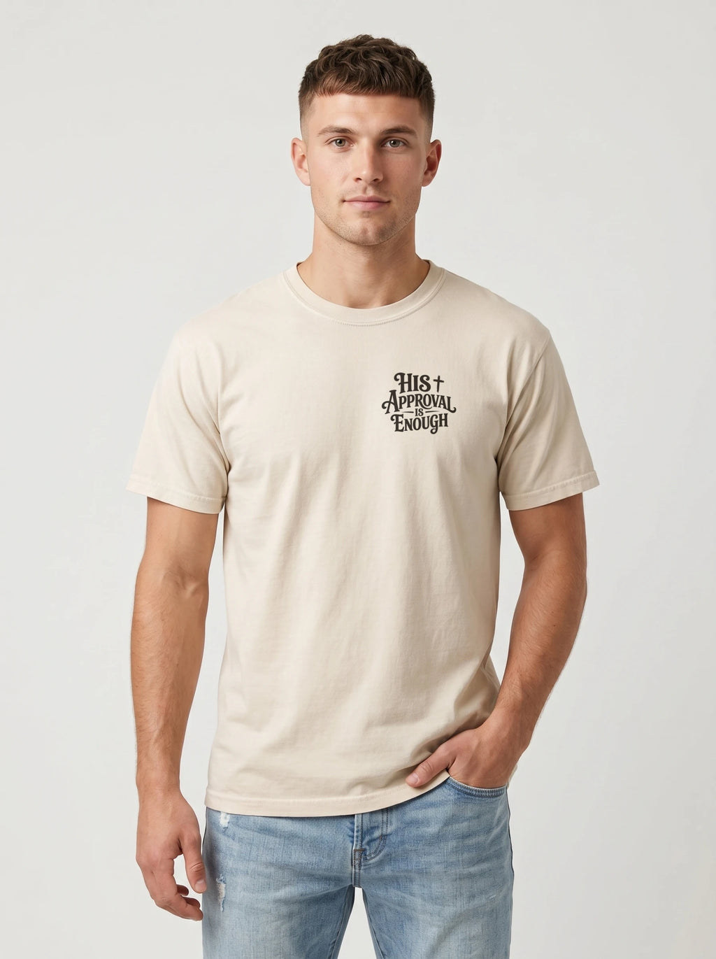Man wearing cream Comfort Colors t-shirt with small 'His Approval Is Enough' faith graphic on left chest