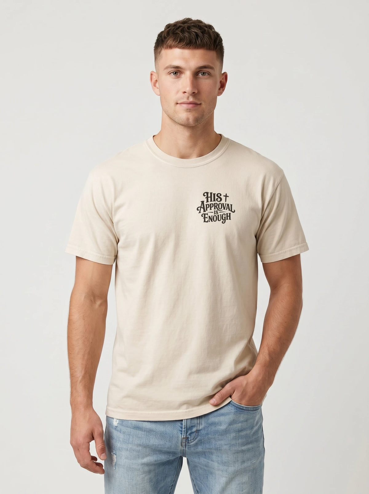 Man wearing cream Comfort Colors t-shirt with small 'His Approval Is Enough' faith graphic on left chest