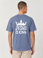 A man viewed from the back wearing a heathered blue t-shirt with a white graphic print of a crown and the text 'JESUS IS KING'.