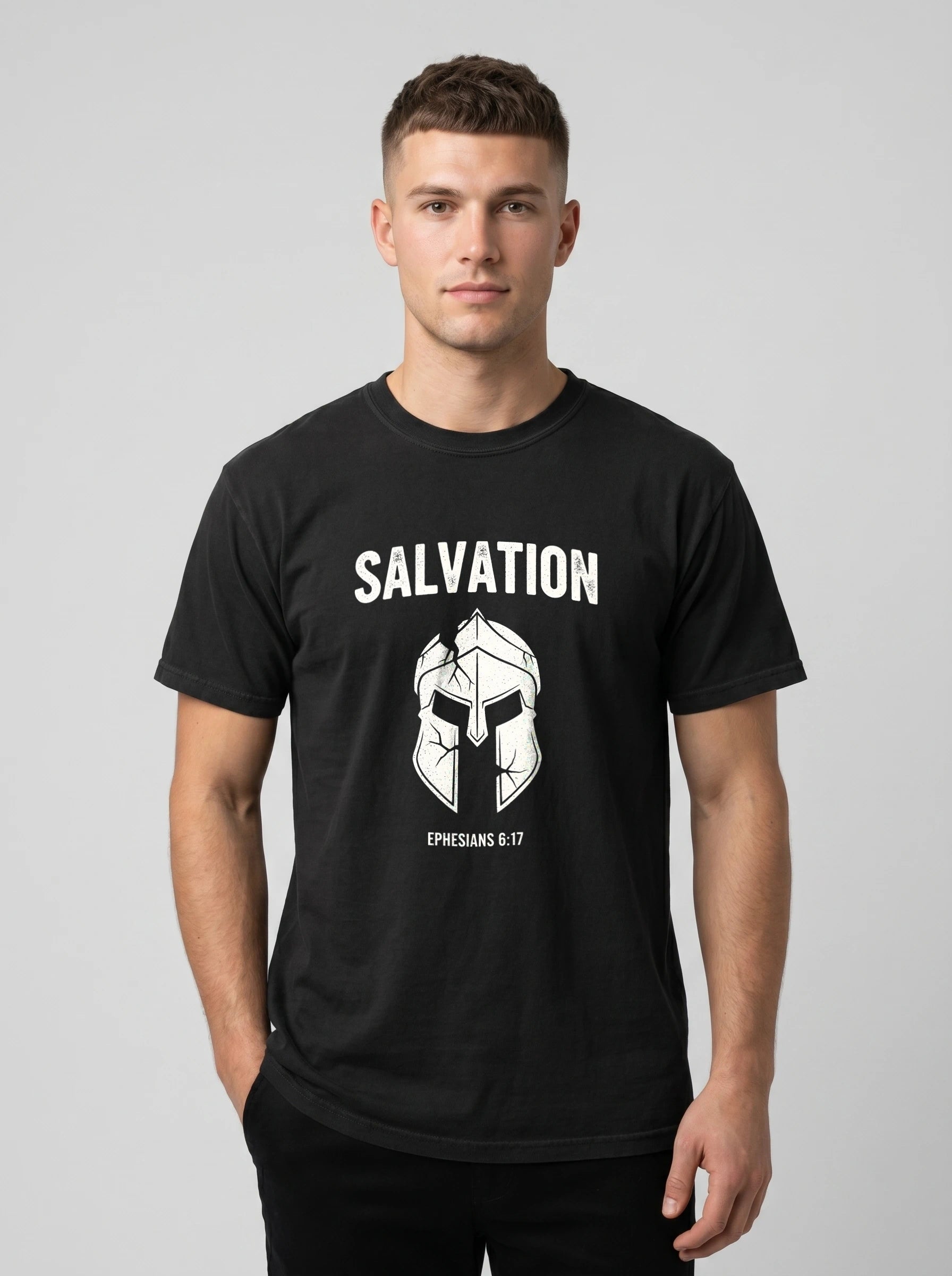 A man wearing a black crewneck t-shirt with a white graphic print of a helmet and the text 'SALVATION' and 'EPHESIANS 6:17'.