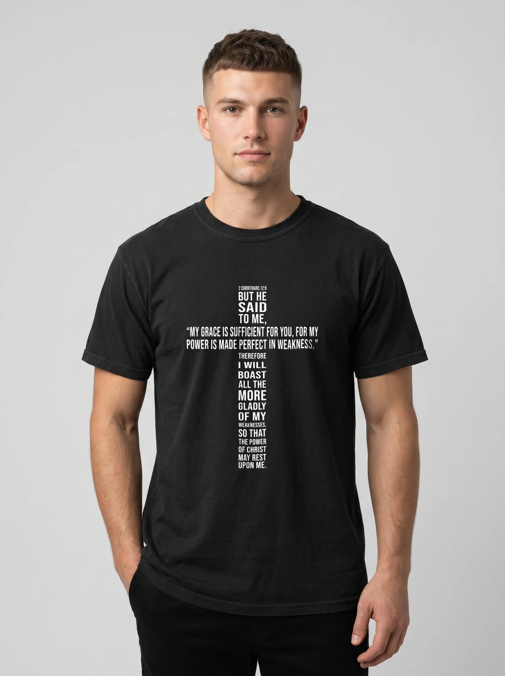 Person wearing a black T-shirt with white text quoting 2 Corinthians 12:9: “My grace is sufficient for you, for my power is made perfect in weakness.”