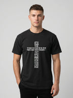 Person wearing a black T-shirt with white text quoting 2 Corinthians 12:9: “My grace is sufficient for you, for my power is made perfect in weakness.”