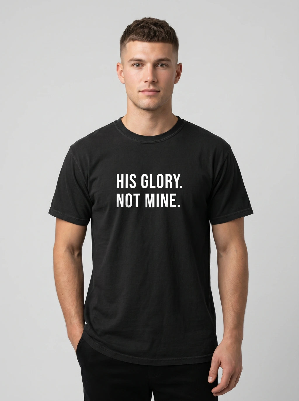 Man wearing a black Comfort Colors garment-dyed t-shirt printed with 'His Glory. Not Mine.' Christian faith quote