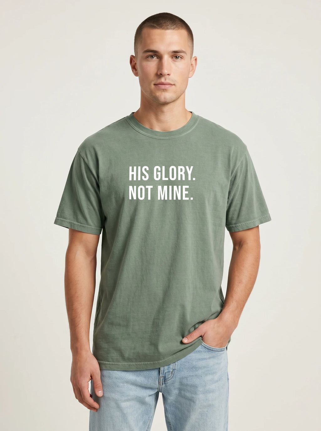 Man wearing a moss green Comfort Colors garment-dyed t-shirt printed with 'His Glory. Not Mine.' Christian faith quote
