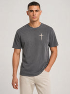 Man wearing dark gray Comfort Colors t-shirt with small cross graphic on left chest