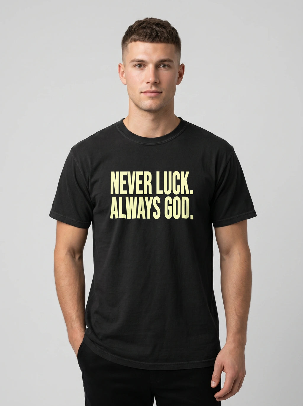 Person wearing a black T-shirt reading “Never luck. Always God.” in pale yellow lettering.