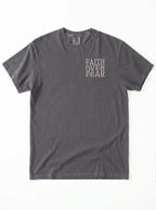 A dark gray short-sleeve t-shirt with the words 'FAITH OVER FEAR' printed vertically in a light beige font on the left chest, displayed flat against a white background.