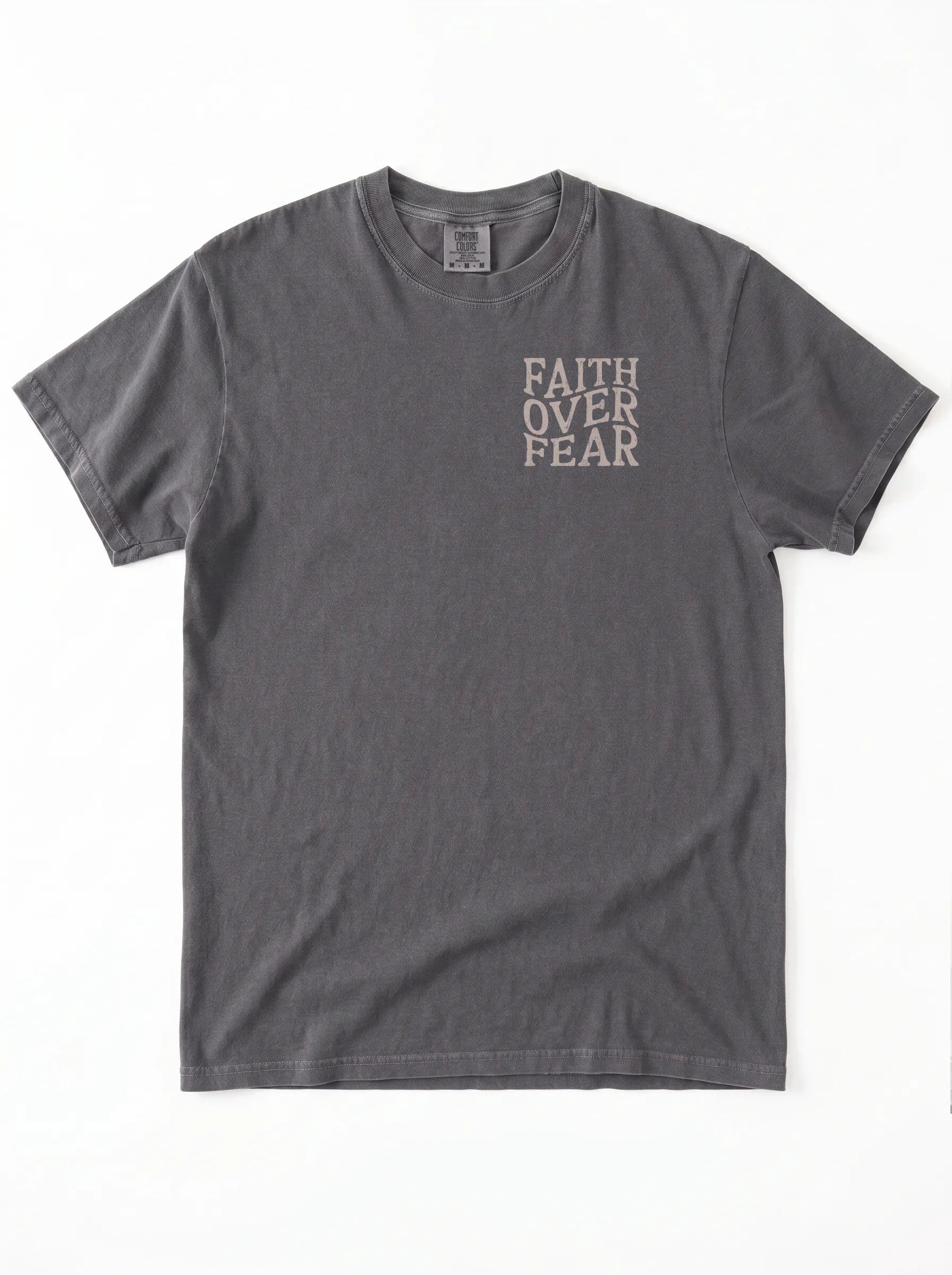 A dark gray short-sleeve t-shirt with the words 'FAITH OVER FEAR' printed vertically in a light beige font on the left chest, displayed flat against a white background.