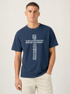 Person wearing a navy T-shirt with white text quoting 2 Corinthians 12:9: “My grace is sufficient for you, for my power is made perfect in weakness.”